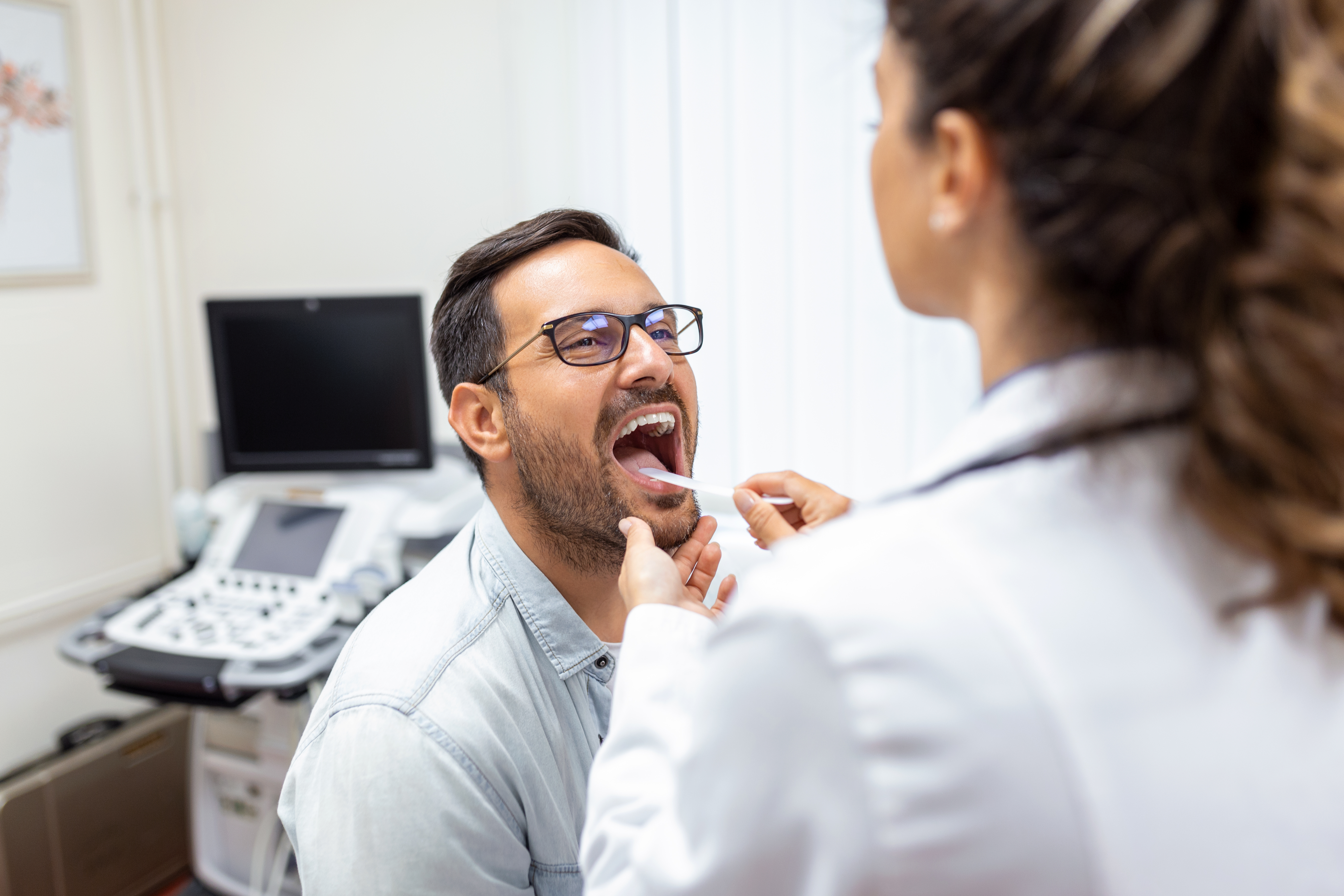 	doctor-using-inspection-spatula-examine-patient-throat